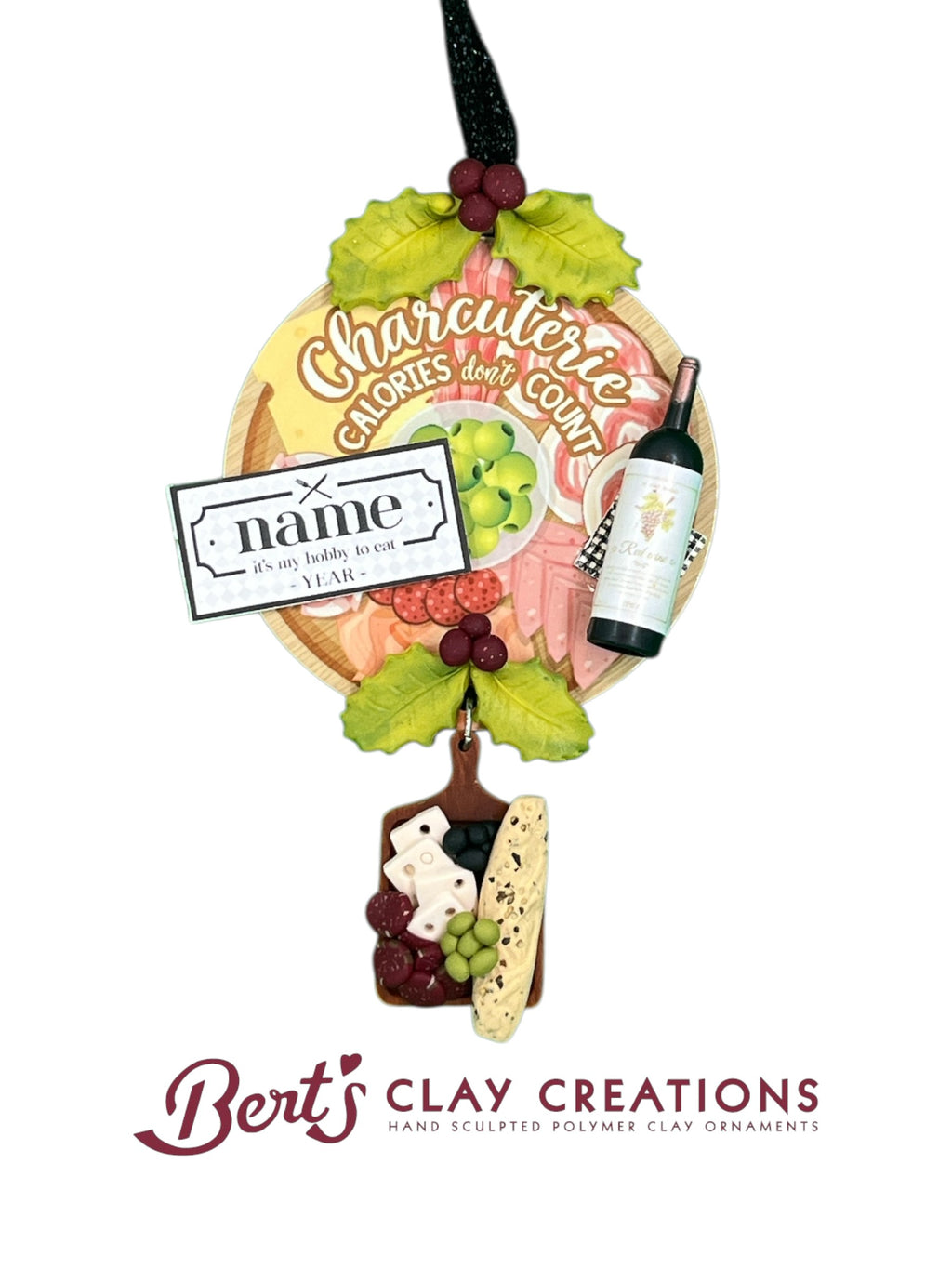• Hand-sculpted polymer clay ornament with charcuterie theme
• Circular plaque with “Charcuterie Calories Don’t Count” text
• Miniature wine bottle and clay food items: grapes, cheese, meats
• Customizable nameplate with “it’s my hobby to eat” and year
• Dangling charcuterie board with crackers, cheese, grapes, and olives
• Red ribbon for hanging and gift-ready packaging
• Fun and festive ornament for food and wine lovers