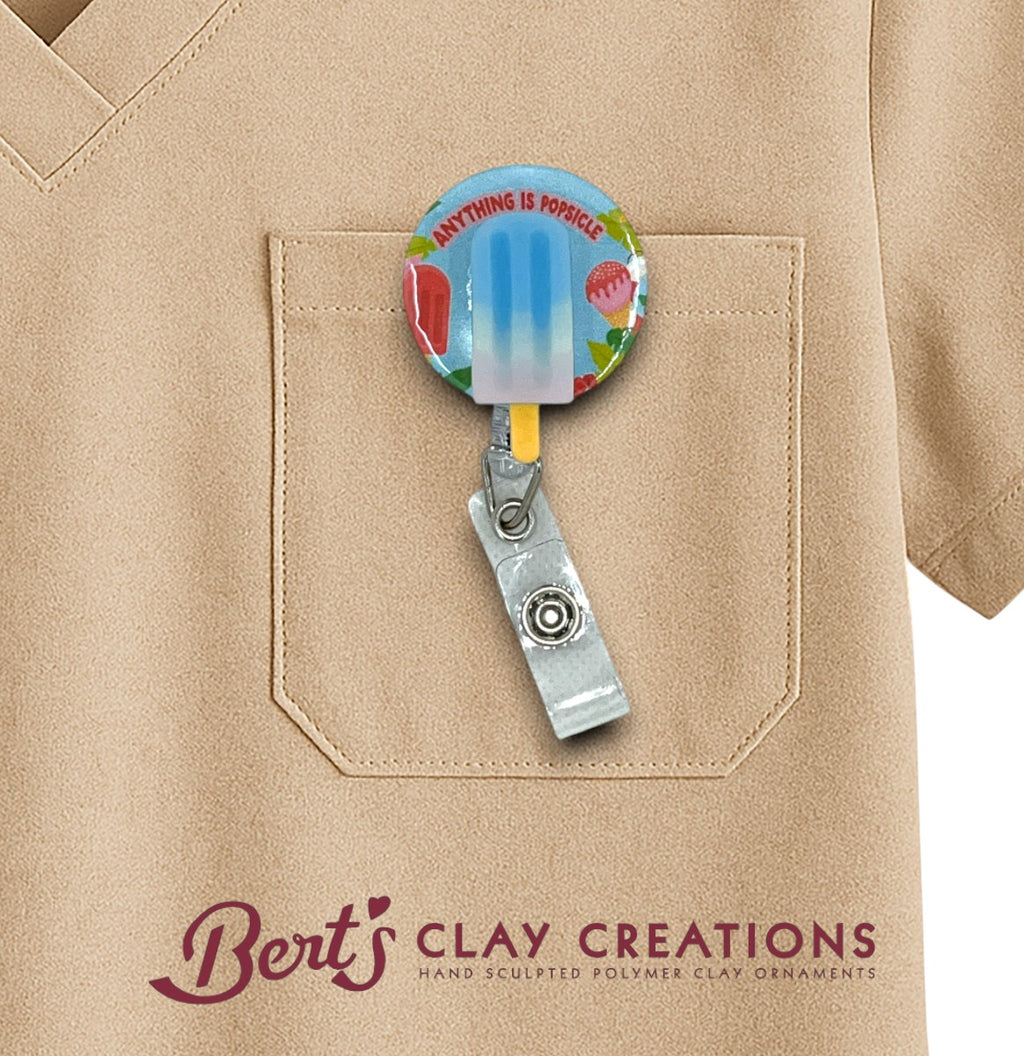 Colorful badge holder with 'Bert's Clay Creations' logo on a beige shirt pocket.
