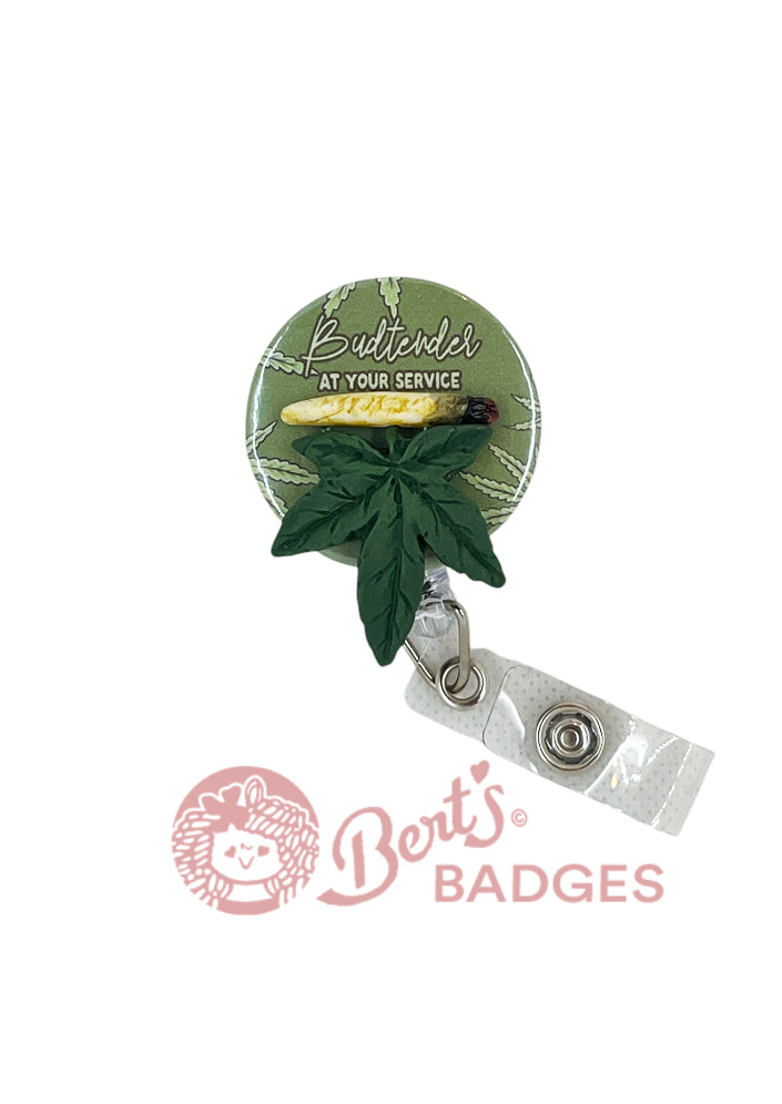 A retractable ID holder with a cannabis leaf design and the text 'Budtender At Your Service'. It includes a clip and a badge reel swivel clip.