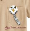 Retractable badge holder with bee design on a beige shirt, featuring 'Bert's Clay Creations' logo.