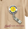 Badge holder with 'You're Ducking Amazing!' text and colorful design on a beige shirt pocket, featuring Bert's Clay Creations branding.