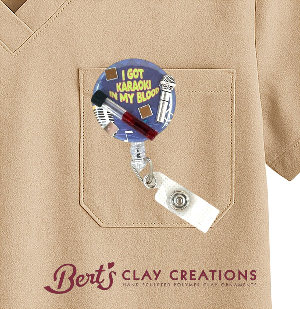Badge holder with 'I Got Karaoke in My Blood' design on a beige shirt, featuring 'Bert's Clay Creations' branding.