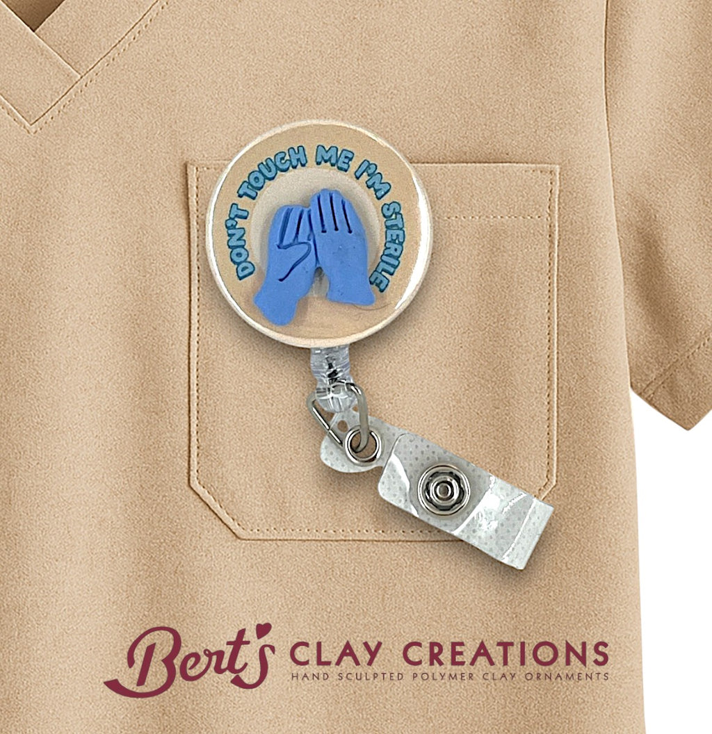 Badge holder with 'Don't Touch Me I'm Sterile' design on a beige shirt, branded 'Bert's Clay Creations'.