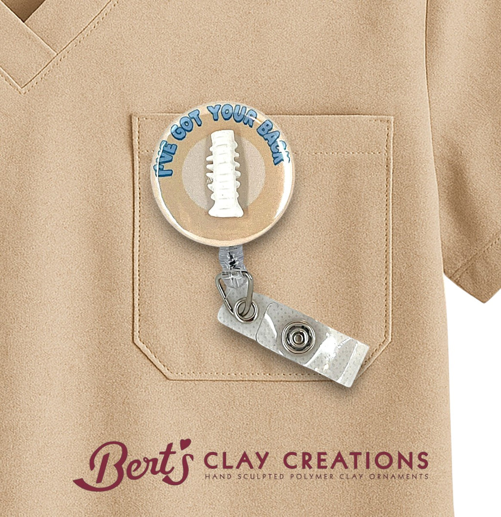 Chiropractor themed Retractable badge holder with 'I've Got Your Back' message attached to a beige shirt, featuring Bert's Clay Creations branding.