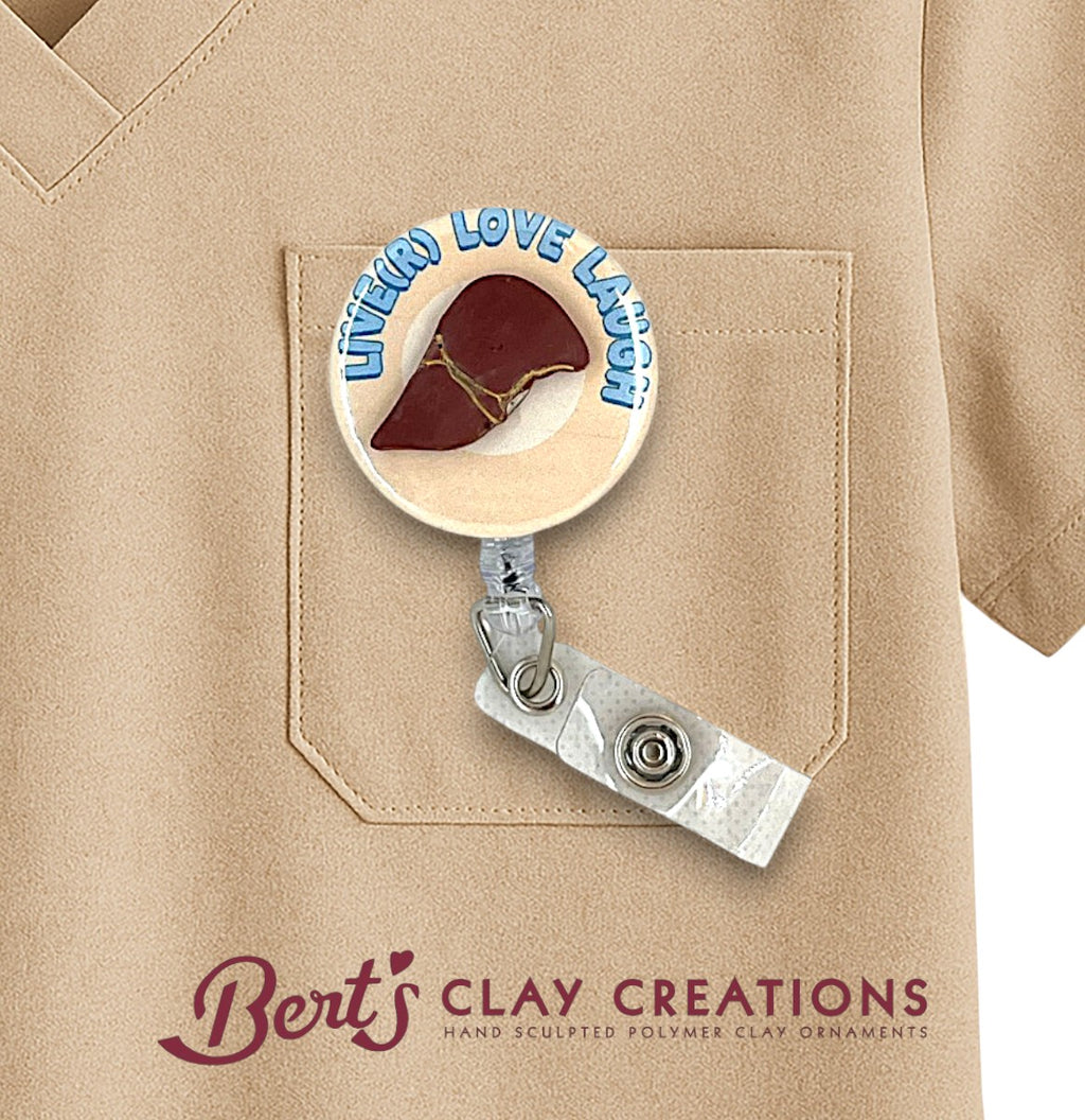 Hepatologist themed Badge holder with 'Live Love Laugh' and a heart design on a beige shirt, featuring 'Bert's Clay Creations' branding.
