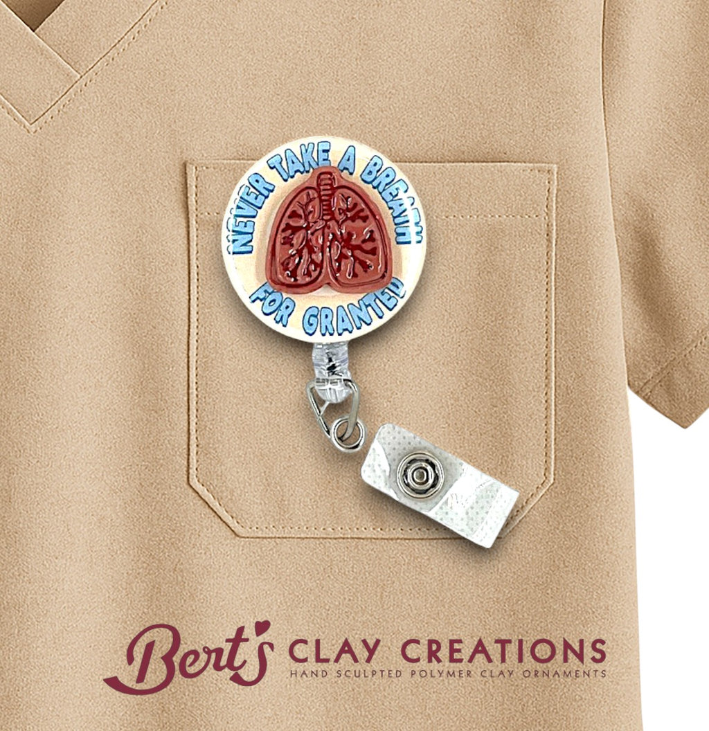Pulmonologist lung doctor themed Badge holder with lungs design and 'Never Take a Breath for Granted' text on a beige shirt, branded 'Bert's Clay Creations'.