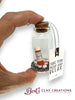 Glass bottle ornament with pills and a tag reading 'Take your meds and relax' held by a hand, with 'Bert's Clay Creations' branding.