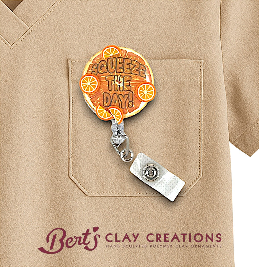 Badge holder with 'Squeeze the Day!' design on a beige shirt, featuring Bert's Clay Creations branding.