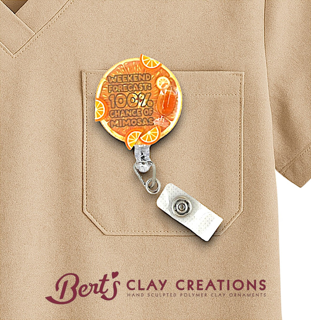 Badge holder with decorative clip attached to a beige shirt, featuring 'Bert's Clay Creations' branding.