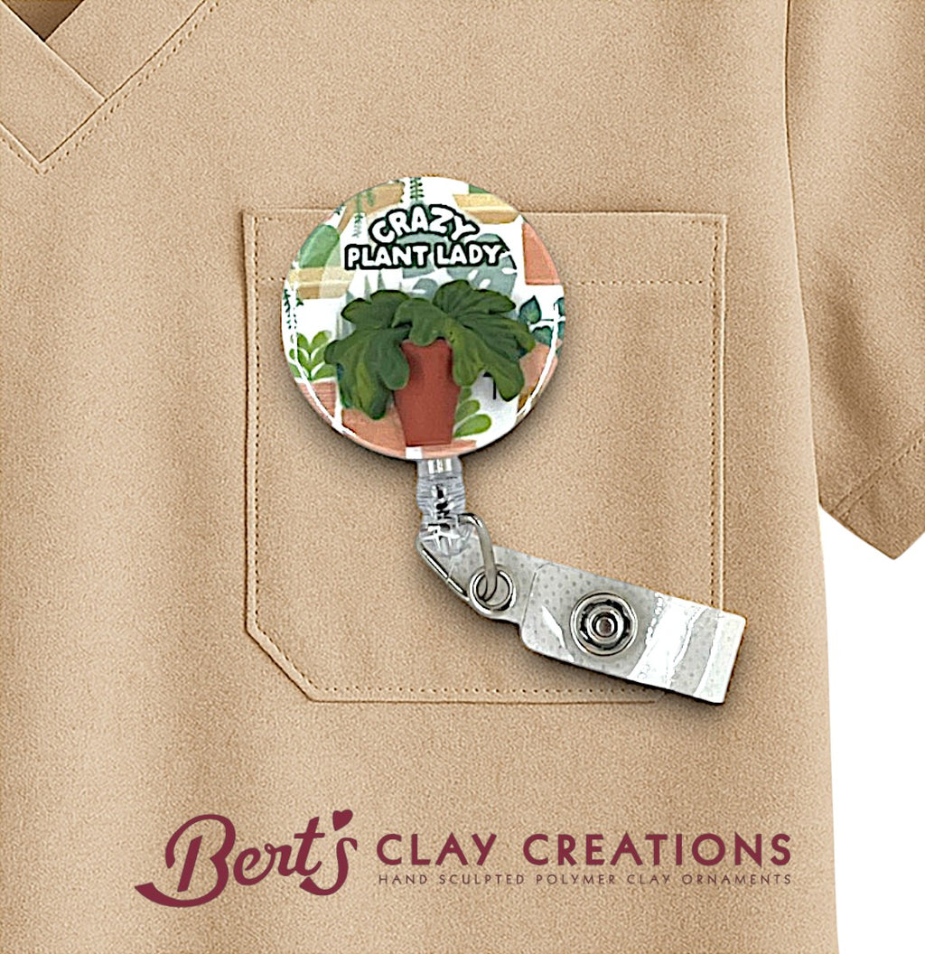 Retractable badge holder with plant design and 'Cra-Z-Plant Lady' text, attached to a beige jacket.