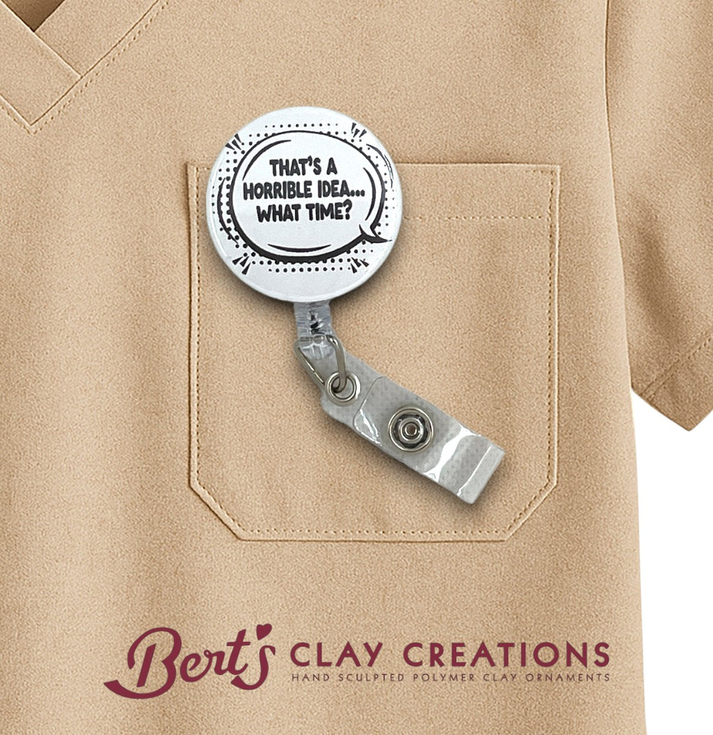 Retractable badge holder with humorous text on a beige shirt with 'Bert's Clay Creations' branding.
