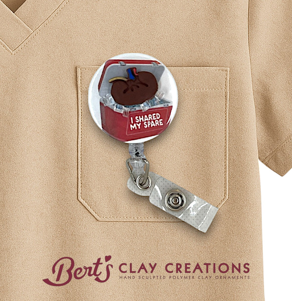 Kidney transplant themed Badge holder with a small ornament on a beige shirt, featuring 'Bert's Clay Creations' branding.