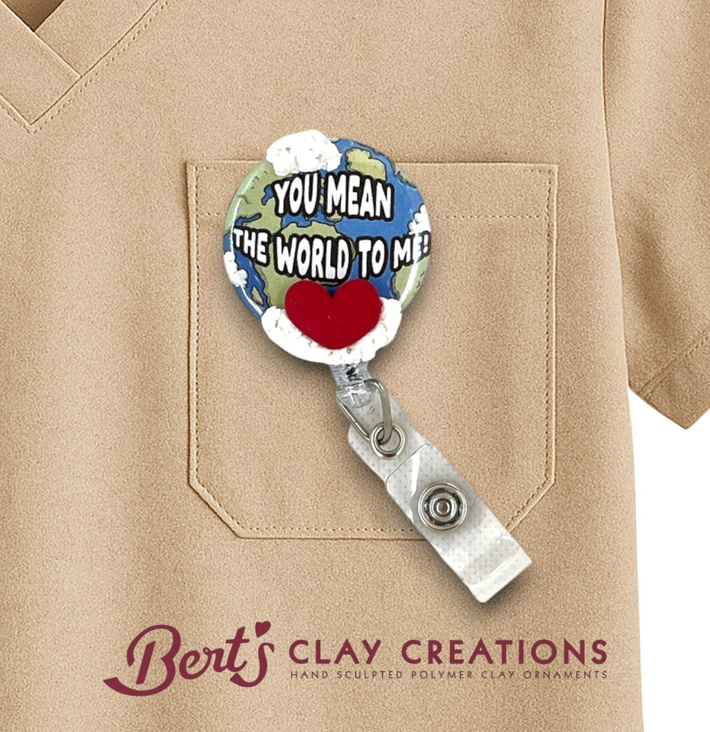 Retractable badge holder with 'You Mean the World to Me' design on a beige shirt, featuring Bert's Clay Creations logo.