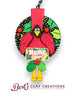 “Hand-sculpted polymer clay cardinal ornament with festive patterned background, holly accents, and customizable name/year plaque – by Bert’s Clay Creations.”
