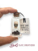 Glass bottle with coffee-themed contents and 'Stop and Smell the Coffee' tag, held by a hand.