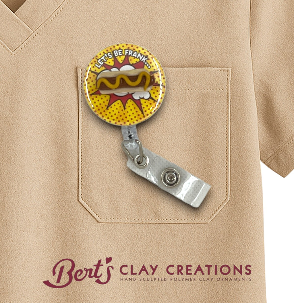 Retractable badge holder with hot dog design on a beige shirt, featuring 'Bert's Clay Creations' branding.